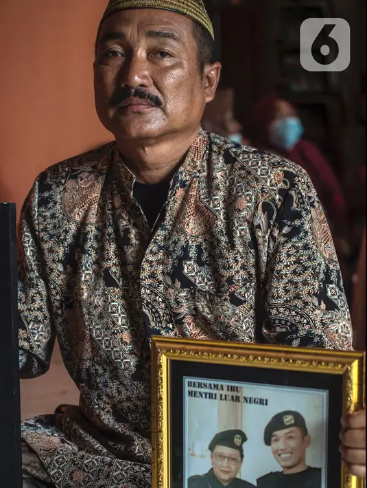 Edy Sujianto menunjukkan foto putranya Letnan Satu Muhammad Imam Adi yang bertugas dalam kapal selam KRI Nanggala 402 di Pasuruan, Jawa Timur, Minggu (25/4/2021). KRI Nanggala 402 hilang kontak di lepas pantai Bali pada 21 April dan kemudian dinyatakan tenggelam dengan 53 awak. (Juni Kriswanto/AFP)