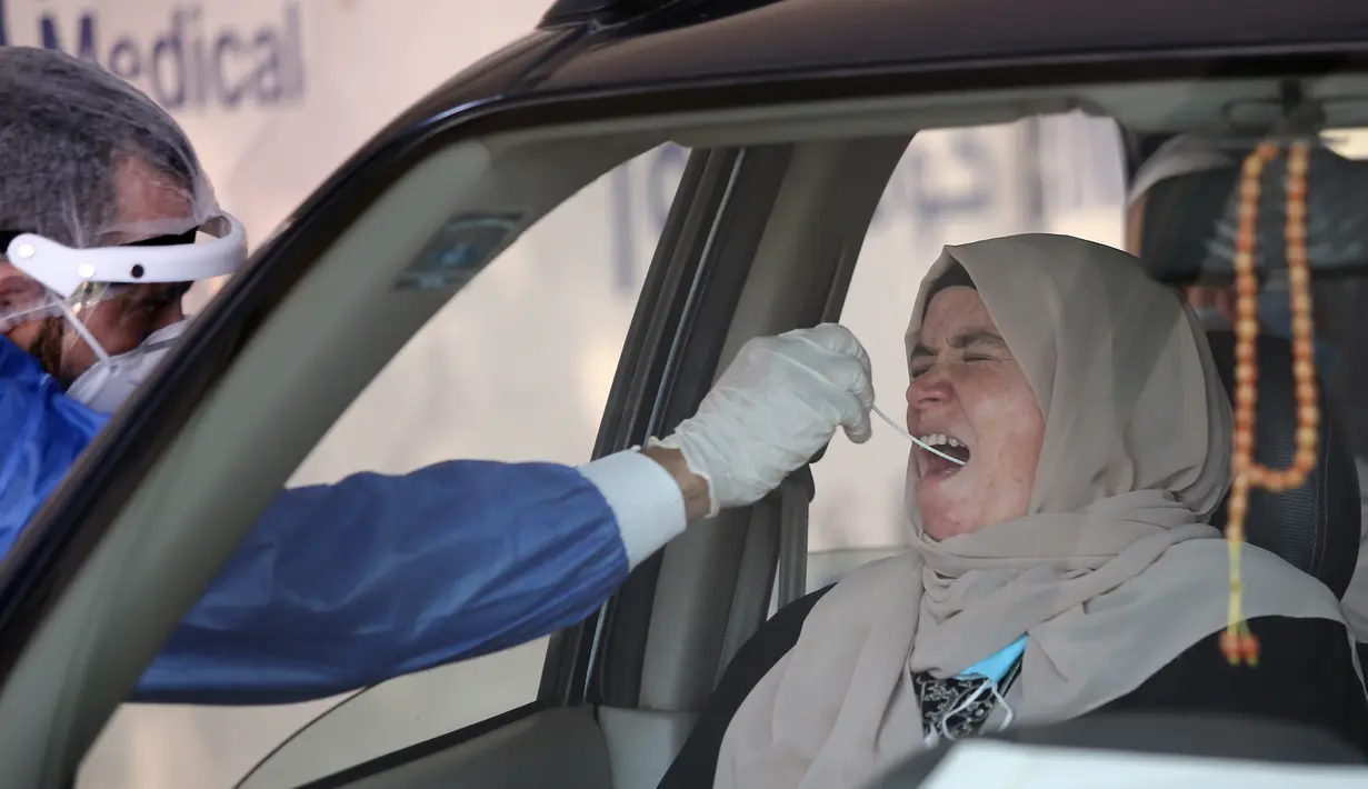 Petugas medis mengambil sampel usap (swab) COVID-19 dari seorang wanita di Rumah Sakit Khusus Universitas Ain Shams, Kairo, Mesir, Senin (13/7/2020). Hingga 13 Juli 2020, jumlah infeksi COVID-19 di Mesir terkonfirmasi telah mencapai angka 83.001 kasus. (Xinhua/Ahmed Gomaa)