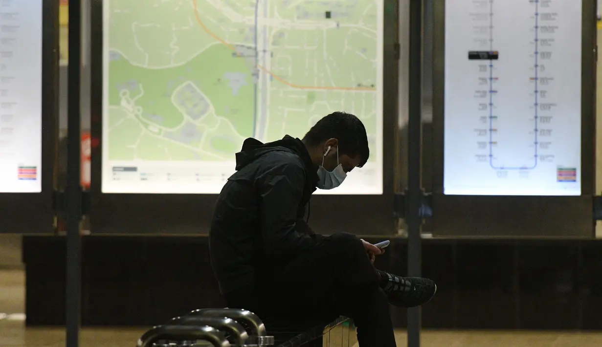 Seorang pria mengenakan masker saat menunggu kereta di sebuah stasiun kereta bawah tanah di Singapura pada 18 November 2020. (Xinhua/Then Chih Wey)