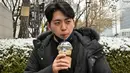 Gambar yang diambil pada 26 Januari 2023 ini menunjukkan akuntan Lee Dae-hee meminum es Americano selama wawancara dengan AFP di sebuah jalan di Seoul, Korea Selatan. Rata-rata orang Korea Selatan minum 353 cangkir per tahun, lebih dari dua kali lipat rata-rata global, menurut sebuah studi tahun 2019 oleh Hyundai Research Institute. (Jung Yeon-je / AFP)