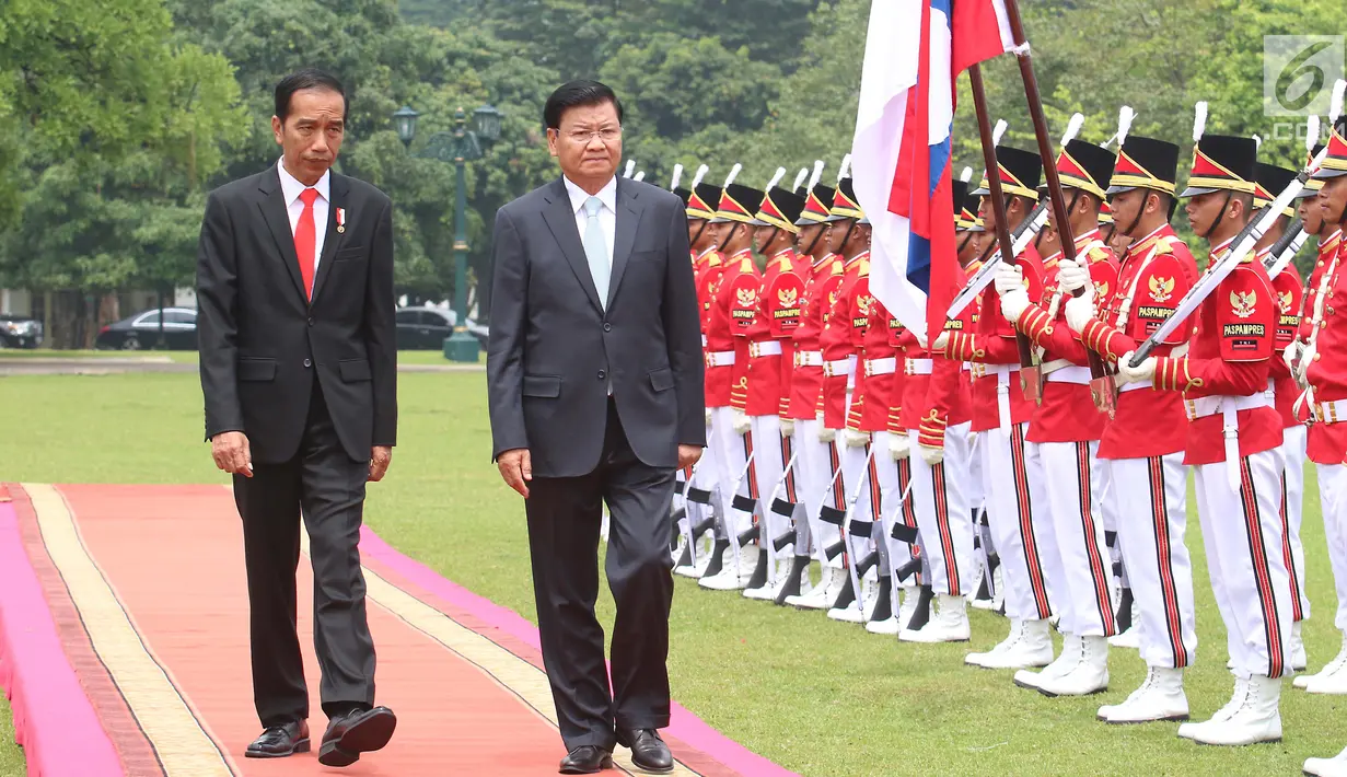 Presiden Joko Widodo (Jokowi) mendampingi PM Republik Demokratik Rakyat, Laos Thongloun Sisoulith melakukan pemeriksaan pasukan kehormatan pada upacara kenegaraan di Istana Kepresidenan Bogor, Jawa Barat, Kamis (12/10). (Liputan6.com/Angga Yuniar)