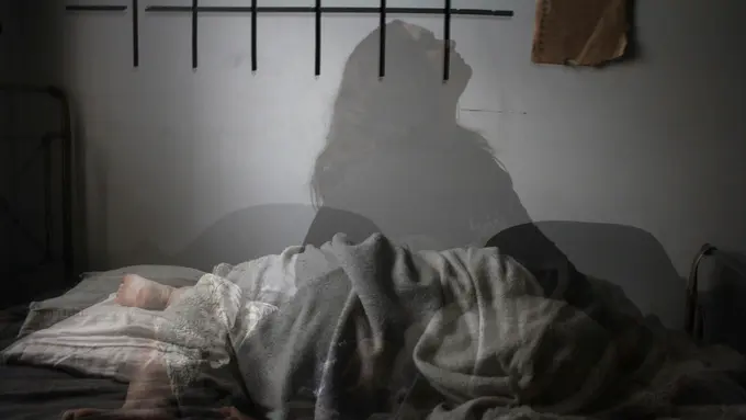 Shadow of woman on bed