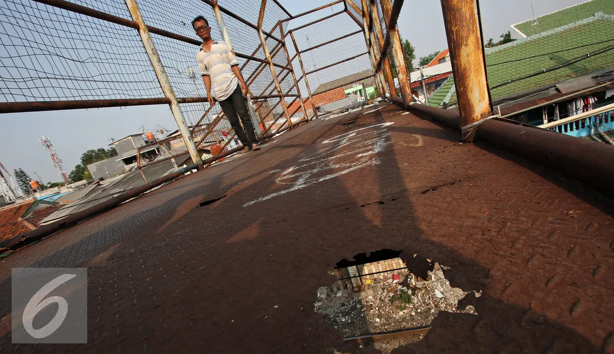 Pejalan kaki melintasi Jembatan Penyeberangan Orang (JPO) yang rusak di kawasan Tebet, Jakarta, Kamis (5/11). Kondisi jembatan yang sudah berkarat dan berlubang tersebut membahayakan pejalan kaki terutama saat malam hari. (Liputan6.com/Immanuel Antonius)