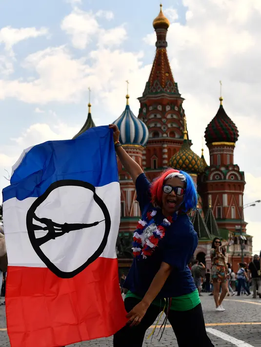 Seoarang fans menbentangkan bendera Prancis di Lapangan Merah di Moskow, Rusia (13/7). Final Piala Piala Dunia 2018 antara Prancis dan Kroasia akan berlangsung di Stadion Luzhniki, Moskow, Rusia. (AFP Photo/Christophe Simon)