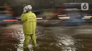 Petugas kepolisian mengatur lalu lintas saat banjir merendam terowongan di Cawang Jakarta, Jumat(19/2/2021). Hujan yang turun sejak semalam membuat sejumlah jalanan di Ibu Kota tergenang banjir dengan ketinggian sekitar 30-50 cm. (merdeka.com/Imam Buhori)