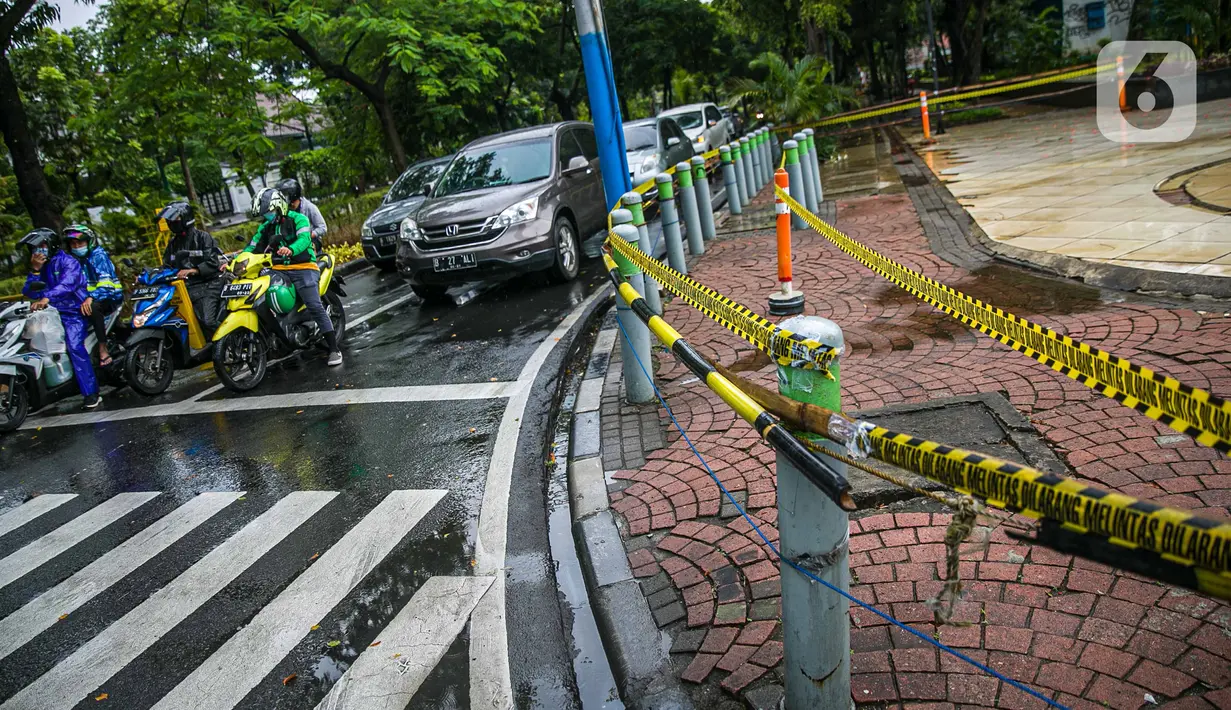 Pengendara menunggu lampu merah di dekat Taman Menteng, Jakarta, Kamis (31/12/2020). Pemprov DKI Jakarta mulai hari ini menutup sementara seluruh taman dan hutan kota di Ibu Kota jelang Tahun Baru 2021 untuk mengantisipasi penyebaran virus Covi-19. (Liputan6.com/Faizal Fanani)