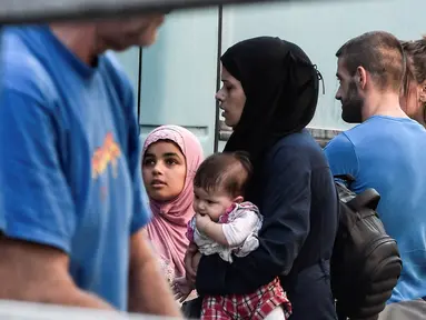 Para migran bersiap naik bus selama operasi polisi di pusat Athena, Yunani (19/9/2019). Polisi di Athena pada 19 September 2019 memindahkan lebih dari 200 migran, termasuk lusinan anak-anak, dari dua tempat di pusat kota sebagai bagian dari pembersihan. (AFP Photo/Louisa Gouliamaki)