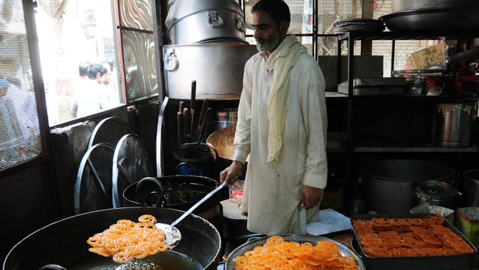 Seorang pria membuat penganan manis tradisional di hari raya Idul Fitri di Peshawar, Pakistan barat laut, pada 25 Mei 2020. Warga Pakistan memiliki tradisi memakan penganan manis saat merayakan Idul Fitri, yang menandai akhir bulan puasa Ramadan. (Xinhua/Saeed Ahmad)