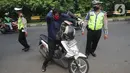 Petugas gabungan memberhentikan pengendara motor yang tidak memakai masker saat penyekatan kendaraan menuju Jakarta di Kelapa Dua, Jagakarsa, Jakarta Selatan, Rabu (27/05/2020). Pemprov DKI Jakarta menerapkan pengetatan bagi para calon pendatang usai mudik Lebaran 2020. (merdeka.com/Arie Basuki)