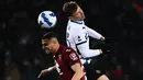 Gelandang Torino, Rolando Mandragora (kiri) dan gelandang Inter Milan Nicolo Barella berebut bola udara pada pertandingan lanjutan Liga Serie A Italia di stadion Olimpiade di Turin, Senin (14/3/2022). Dengan hasil ini Inter Milan turun ke peringkat ketiga dengan 59 poin. (AFP/Marco Bertorello)
