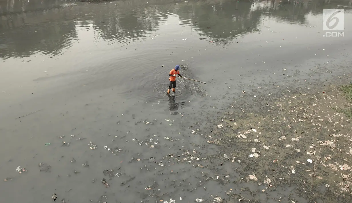 Pekerja membersihkan sampah yang mengotori aliran Kanal Banjir Timur (KBT) di Jakarta, Sabtu (15/9). Banyaknya limbah rumah tangga dan limbah industri menyebabkan kanal pengendali banjir tersebut selalu tercemari sampah. (Liputan6.com/Immanuel Antonius)