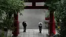 Seorang pria yang mengenakan masker pelindung untuk membantu mengekang penyebaran virus corona COVID-19 sebelum menaiki tangga curam sebuah kuil di Tokyo, Jepang, Senin (12/10/2020). Tokyo mengonfirmasi lebih dari 70 kasus COVID-19 pada hari Senin. (AP Photo/Eugene Hoshiko)