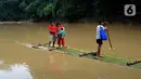 Warga menyeberangi Sungai Cikaniki dengan rakit di Rumpin, Bogor, Jawa Barat, Rabu (15/1/2020). Akibat banjir bandang merobohkan jembatan yang menghubungkan Desa Tonjong Rumpin dan Desa Kantalarang Leuwiliang, warga terpaksa memanfaatkan perahu rakit untuk melintas. (merdeka.com/Arie Basuki)