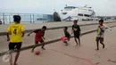 Seorang berusaha mengontrol bola saat bermain bola di pelataran Pelabuhan Kali Adem, Muara Angke, Jakarta, Rabu (4/1). Mereka memanfaatkan Pelabuhan Kali Adem sebagai arena bermain selama mengisi masa liburan sekolah. (Liputan6.com/Gempur M Surya)
