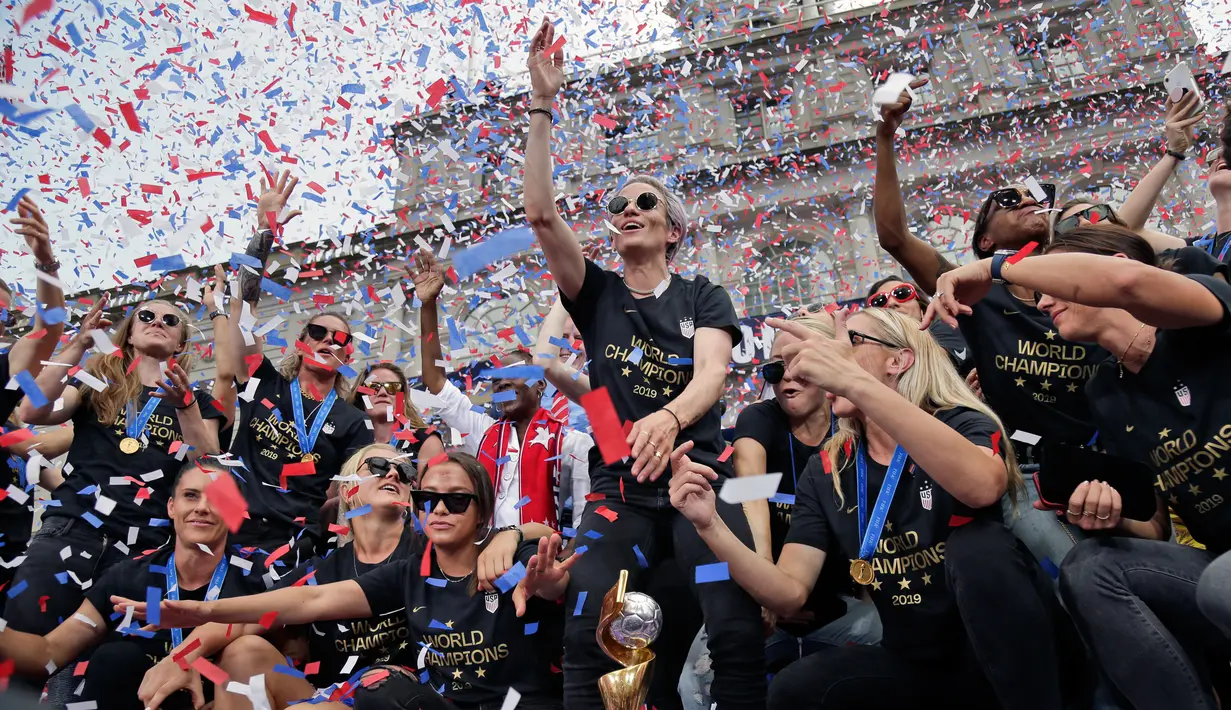 Pemain timnas sepak bola wanita Amerika Serikat (AS), Megan Rapinoe (tengah) bersama rekan-rekannya merayakan kemenangan pada Piala Dunia Wanita 2019 saat parade di New York, AS, Rabu (10/7/2019). AS menjuarai Piala Dunia Wanita 2019 usai mengalahkan Belanda di final. (AP Photo/Seth Wenig)