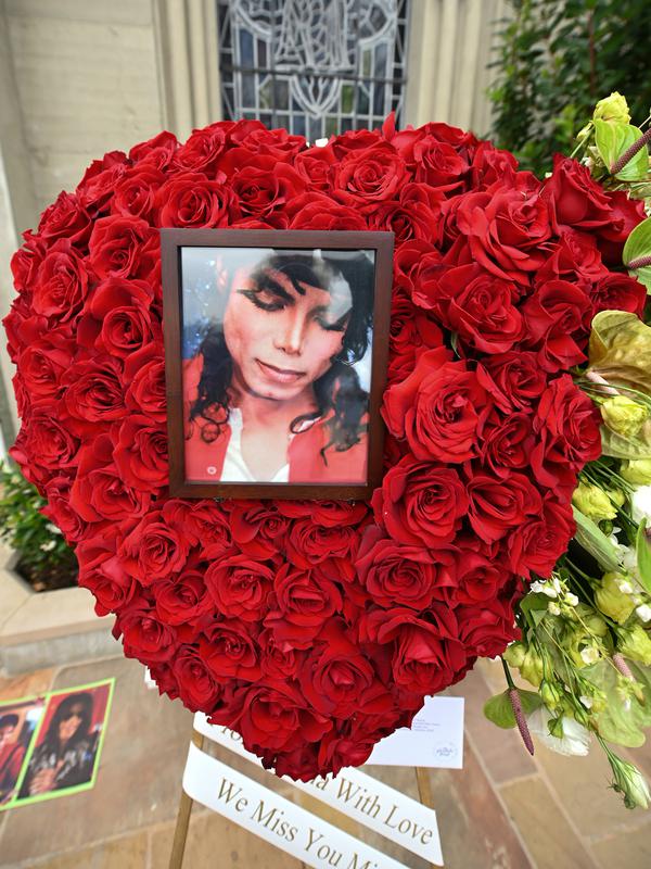 Foto dan bunga diletakkan di luar tempat peristirahatan terakhir Michael Jackson di mausoleum Holly di Terrace Forest Lawn Cemetery, California, Selasa (25/6/2019). Tepat pada hari ini sepuluh tahun yang lalu berita kematian King of Pop Michael Jackson sempat mengguncang dunia. (Robyn Beck/AFP)