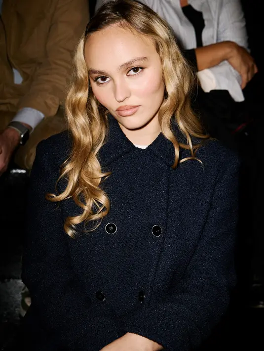 Lily-Rose Depp tampil feminin dengan double breasted tweed dan rok mini hitam [Chanel]