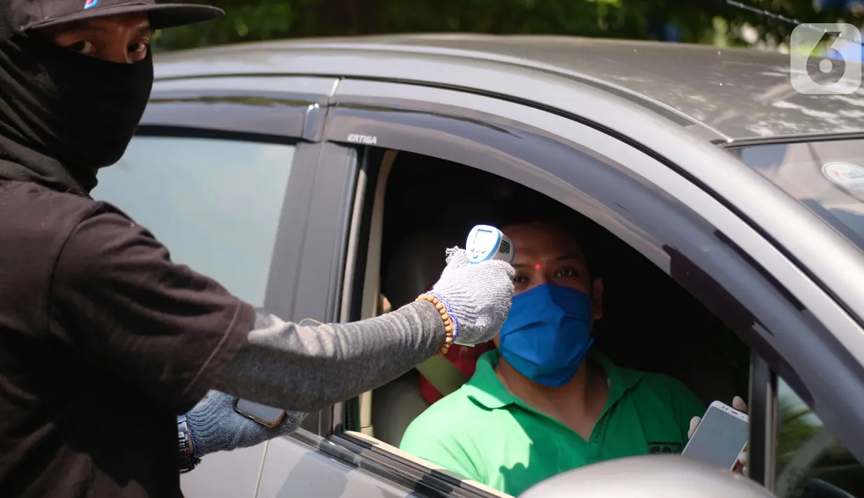 Petugas mengecek suhu tubuh pengemudi di Posko Aman Bersama Gojek, Kemayoran, Jakarta, Kamis (23/4/2020). Sebanyak 130 titik posko telah dioperasikan di 16 kota dengan 3 jenis layanan drive thru selama pandemi Covid-19. (Liputan6.com/HO/Ading)