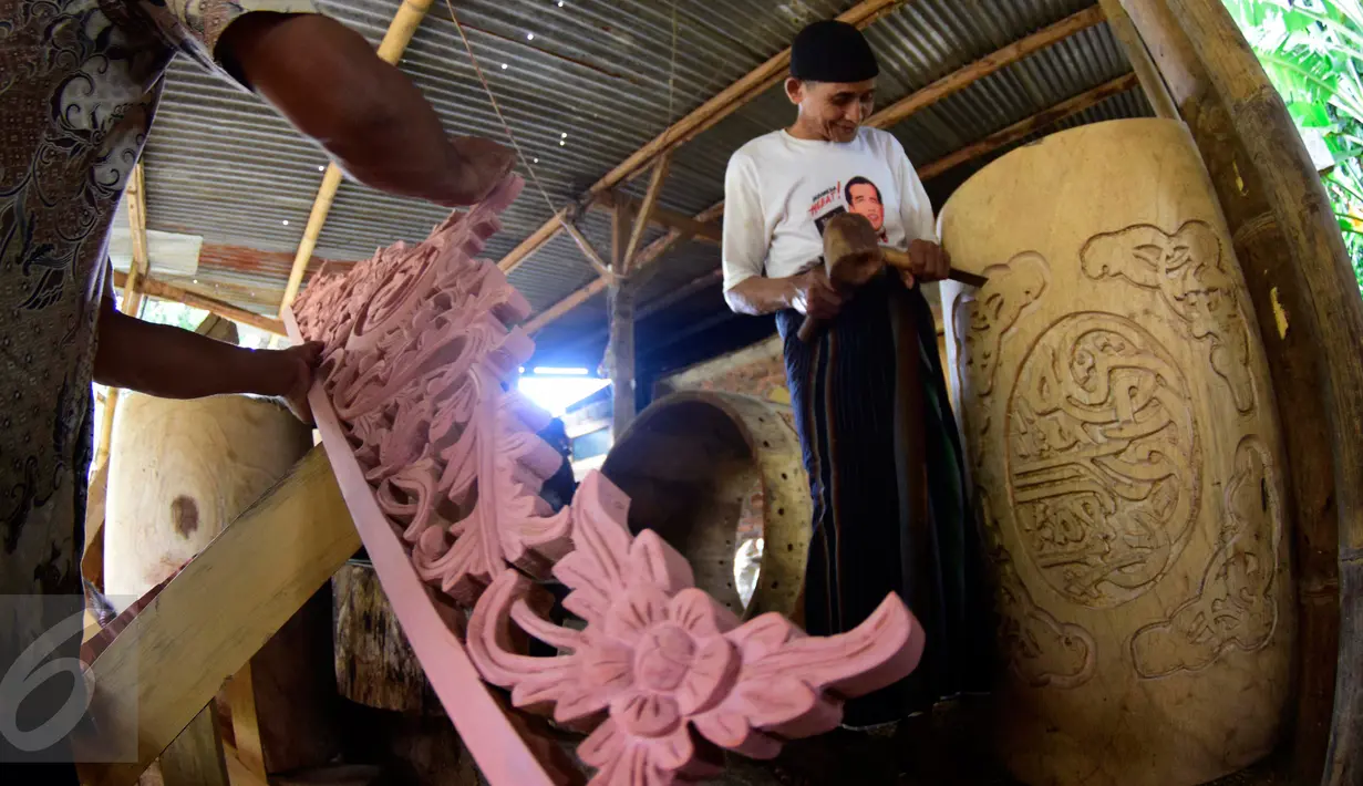 Pengrajin  menyelesaikan ukiran di atas kayu untuk dijadikan bedug di Desa Bleder, Ngasinan, Grabag, Magelang, Jawa Tengah, Jumat (3/6). Menjelang Ramadan, pengrajin bedug mulai kebanjiran order dari berbagai kota di Indonesia. (Liputan6.com/Gholib)