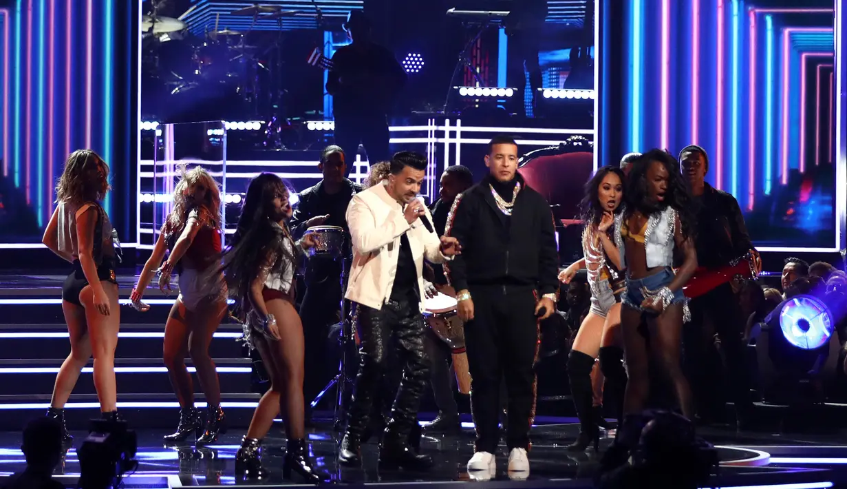Luis Fonsi dan Daddy Yankee ditemani penari wanita seksi membawakan Despacito di panggung ajang Grammy Awards 2018 di New York, Minggu (28/1). Namun sayangnya, Justin Bieber tak hadir untuk melengkapi penampilan tersebut. (Matt Sayles/Invision/AP)