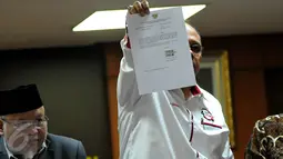 Wakil Ketua Junimart Girsang menunjukan surat pengunguran diri Setya Novanto dari Ketua DPR, Jakarta, Rabu (16/12/2015). Dengan adanya surat tersebut maka masa sidang Pelanggaran Etik Setya Novanto dinyatakan selesai. (Liputan6.com/Johan Tallo)