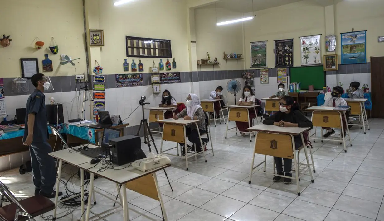 Siswa mengikuti pembelajaran tatap muka (PTM) di sebuah sekolah di Surabaya, Jawa Timur, Senin (6/9/2021). Pemerintah kembali membuka sekolah di tengah pandemi COVID-19. (JUNI KRISWANTO/AFP)