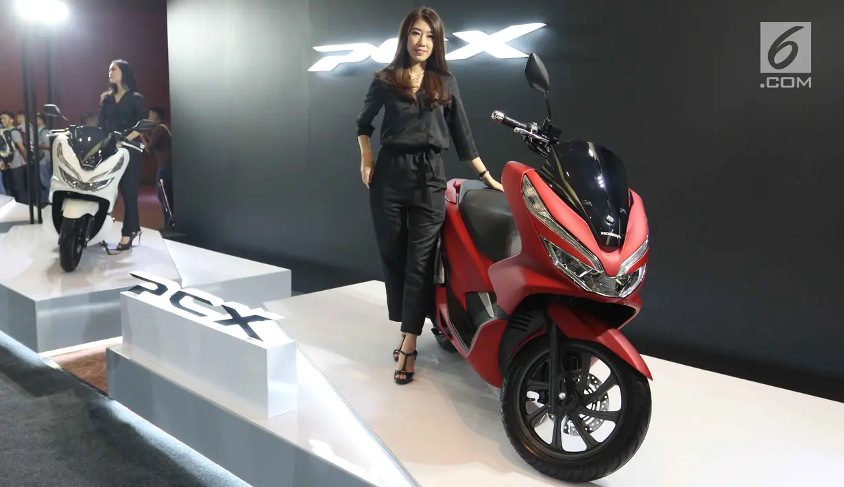 Seorang wanita berdiri di samping skutik all new Honda PCX saat peluncurannya di Jakarta, Rabu (7/2). Menurut Vice Presiden PT AHM Johannes Loman, all new PCX diciptakan karena banyaknya pecinta skutik premium di Tanah Air. (Liputan6.com/Angga Yuniar)