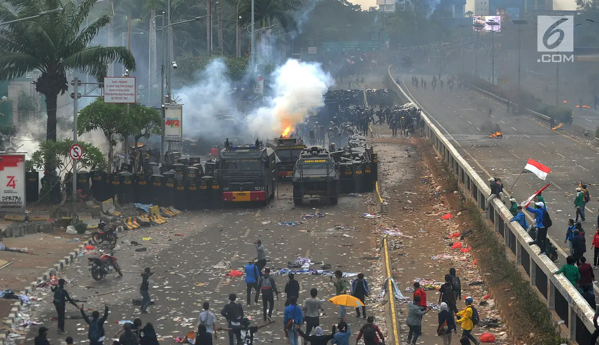 Polisi menembakkan gas air mata ke arah mahasiswa saat demonstrasi menolak pengesahan RUU KUHP dan revisi UU KPK di depan Gedung DPR, Jakarta, Selasa (24/9/2019). Polisi menghalau mahasiswa yang berusaha masuk ke area Gedung DPR. (merdeka.com/Arie Basuki)