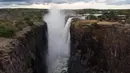 Kabut naik dari ngarai di air terjun Victoria, salah satu air terjun terbesar di dunia, di  Zimbabwe pada 10 Desember 2019. Menurut pejabat setempat, pada tahun ini Air Terjun Victoria mengalami penurunan debit air yang belum pernah terjadi sebelumnya. (ZINYANGE AUNTONY/AFP)