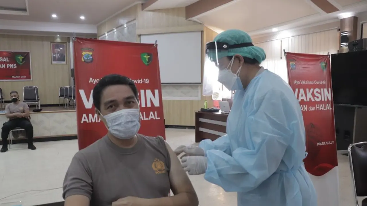 Kabid Humas Polda Sulut Kombes Pol Jules Abraham Abast saat menjalani proses vaksinasi Covid-19.