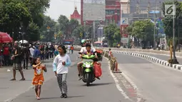 Pengendara motor melintasi arena Car Free Day (CFD) di Jalan Warung Jati Barat, Jakarta, Minggu (17/9).  Beberapa pengendara motor terlihat bebas menerabas jalan yang dipenuhi orang yang sedang berolahraga dan berjualan. (Liputan6.com/Immanuel Antonius)