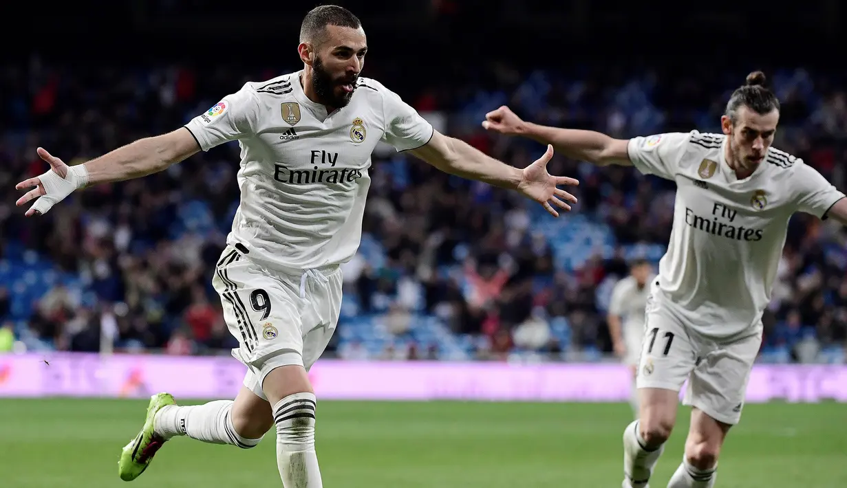 Striker Real Madrid, Karim Benzema, merayakan gol yang dicetaknya ke gawang Huesca pada laga La Liga Spanyol di Stadion Santiago Bernabeu, Madrid, Minggu (31/3). Madrid menang 3-2 atas Huesca. (AFP/Javier Soriano)