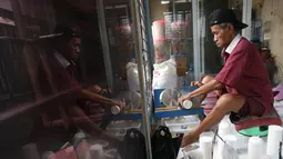 Usaha rumahan yang dirintis sejak tahun 1983 ini dipasarkan dengan harga bervariasi, mulai dari Rp10 ribu hingga Rp 300 ribu. Tampak dalam foto, pekerja menyelesaikan pembuatan keripik tempe di rumah usaha Keripik Tempe Mama Tina, Kebayoran Baru, Jakarta Selatan, Kamis (7/5/2026). (merdeka.com/Arie Basuki)