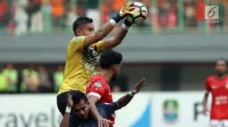 Penjaga gawang Persija, Andritany berjibaku menangkap bola saat laga melawan PSM Makassar pada lanjutan Liga 1 Indonesia di Stadion Patriot Candrabhaga, Bekasi, Selasa (15/8). Laga berakhir imbang 2-2. (Liputan6.com/Helmi Fithriansyah)
