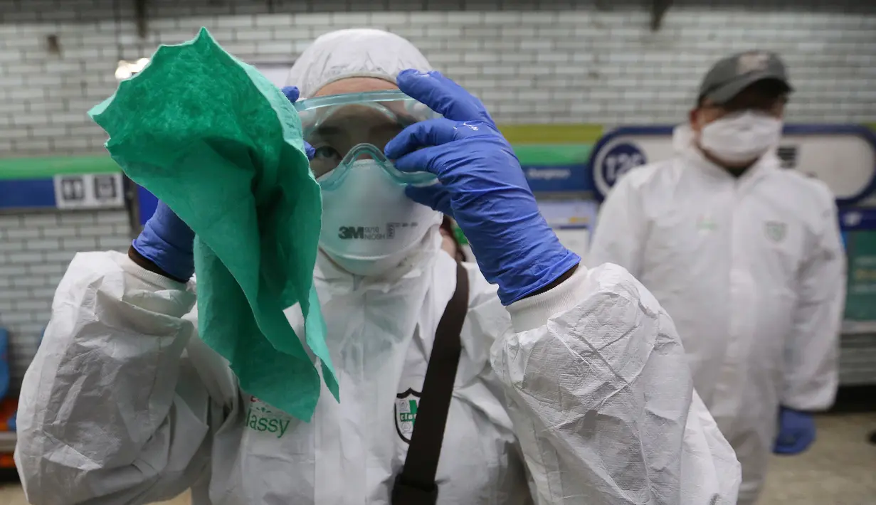 Petugas medis menyesuaikan kacamatanya saat akan menyemprotkan cairan disinfektan sebagai tindakan pencegahan virus corona (COVID-19) di Seoul, Korea Selatan, Jumat (21/2/2020). Jumlah pasien virus corona di Korea Selatan naik 293 kasus dari pengumuman sebelumnya. (AP Photo/Ahn Young-joon)