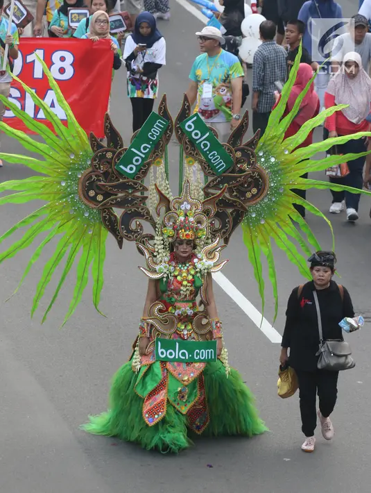 Peserta berkostum Bola.com memeriahkan parade Asian Games 2018 di Jalan Thamrin, Jakarta, Minggu (13/5). Tak hanya dari komunitas, peserta parade ini juga datang dari karyawan PT Elang Mahkota Teknologi (Emtek). (Liputan6.com/Arya Manggala)