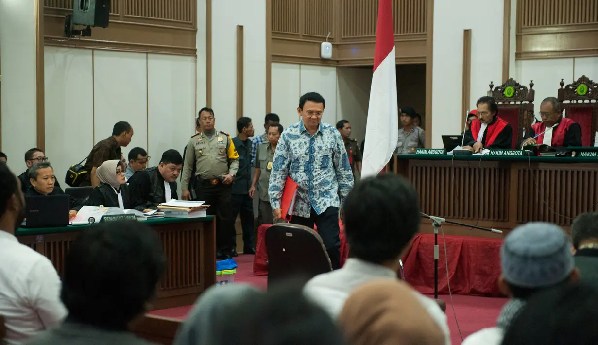 Basuki Tjahaja Purnama (Ahok) berjalan menuju kursi terdakwa untuk menjalani sidang lanjutan di Auditorium Kementan, Jakarta Selatan, Selasa (10/1). Ahok yang langsung masuk ke ruang sidang terlihat menenteng map merah. (Liputan6.com/Hendra Setyawan/Pool)