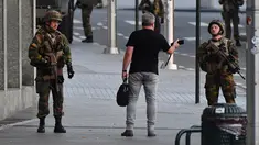 Tentara Belgia berbincang dengan seorang pria di luar Central Station usai sebuah teror ledakan yang terjadi di Brussels, Belgia (20/6). Media Belgia melaporkan bahwa ledakan terjadi di stasiun kereta api Gare Centrale. (AP Photo/Geert Vanden Wijngaert)