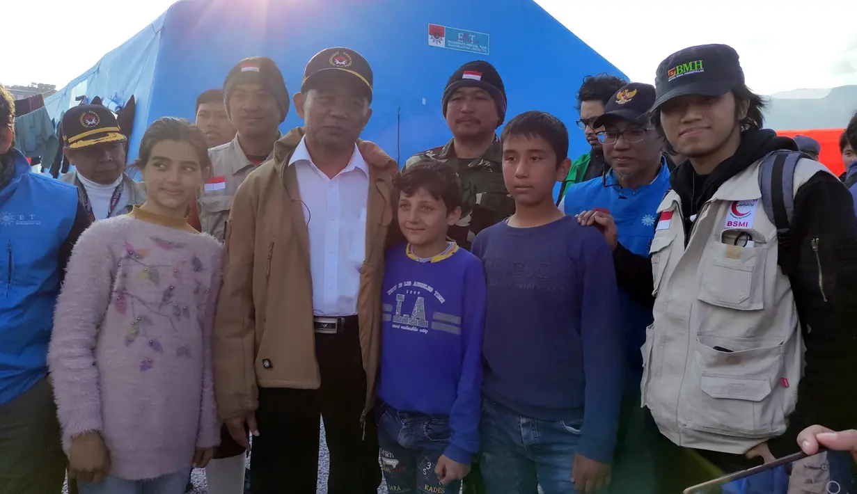 <p>Menteri Koordinator Bidang Pemberdayaan Manusia dan Kebudayaan (Menko PMK) Muhadjir Effendy foto bersama anak-anak korban gempat saat mengunjungi posko emergency medical technician (EMT) di Distrik Hassa, Provinsi Hatay, Turki, Rabu (22/3/2023). Dukungan yang selama ini diberikan pemerintah Indonesia dalam penanganan gempa Turki berupa pengiriman lebih dari 250 personel gabungan, lima pesawat kemanusiaan, 110 ton kargo, 50 kontainer makanan instan, dua dapur umum yang beroperasi 24 jam, dan satu rumah sakit umum. (Liputan6.com/Andry Haryanto)</p>