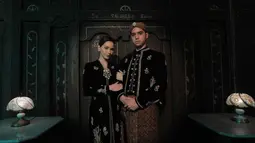 Seperti biasanya, Al Ghazali tampil gagah dalam balutan beskap hitam berbahan velvet. Dilengkapi pula dengan blangkon batik dan bros silver. Sementara, Alyssa tampil elegan dengan kebaya kartini. Motif busana yang dikenakan keduanya pun sama-sama bunga bernuansa emas. (Liputan6.com/IG/@alghazali7)