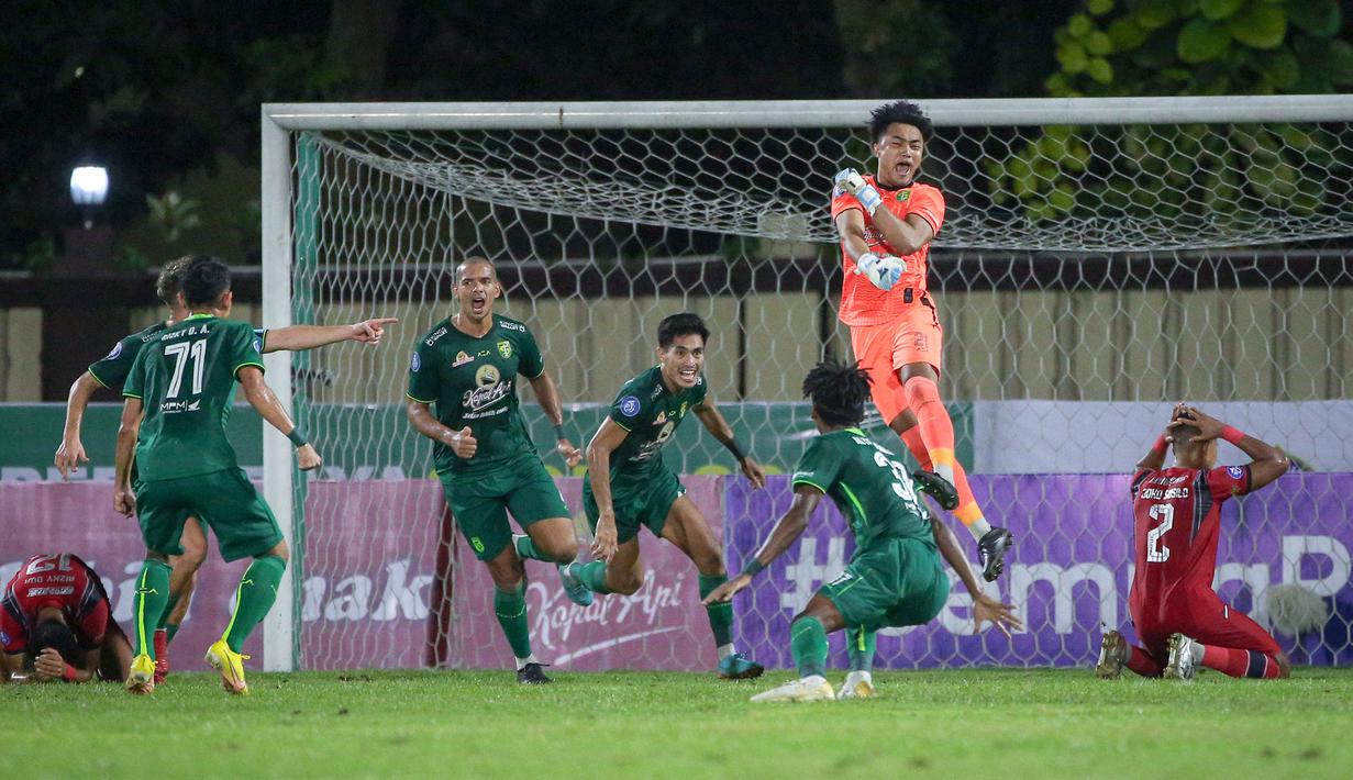 Kiper Persebaya Surabaya, Ernando Ari melakukan selebrasi bersama rekannya setelah berhasil menghalau bola tendangan penalti dari pemain Arema FC, Rizky Dwi Febrianto pada laga lanjutan pekan ke-33 BRI Liga 1 2022/2023 di Stadion PTIK, Jakarta, Selasa (11/04/2023). (Bola.com/Bagaskara Lazuardi)