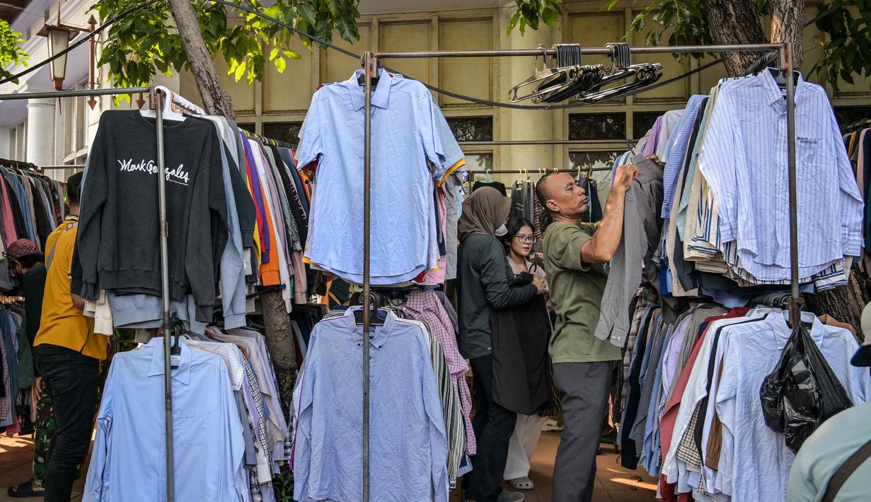 Karenanya, BPS menekankan pentingnya kejujuran data pelaku usaha mikro agar kebijakan pemerintah tepat sasaran. Tampak dalam foto, orang-orang berbelanja pakaian di sebuah kios di salah satu ruas jalan, Surabaya, Jawa Timur, pada Minggu 19 April 2026. (JUNI KRISWANTO/AFP)