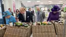 Ratu Inggris Elizabeth II, Pangeran Philip, Pangeran Charles berserta istrinya Ratu Camilla, melihat makanan yang dijual di pasar swalyan Waitrose saat kunjungannya ke Kota Poundbury, Inggris (27/10). (Reuters/Justin Tallis)