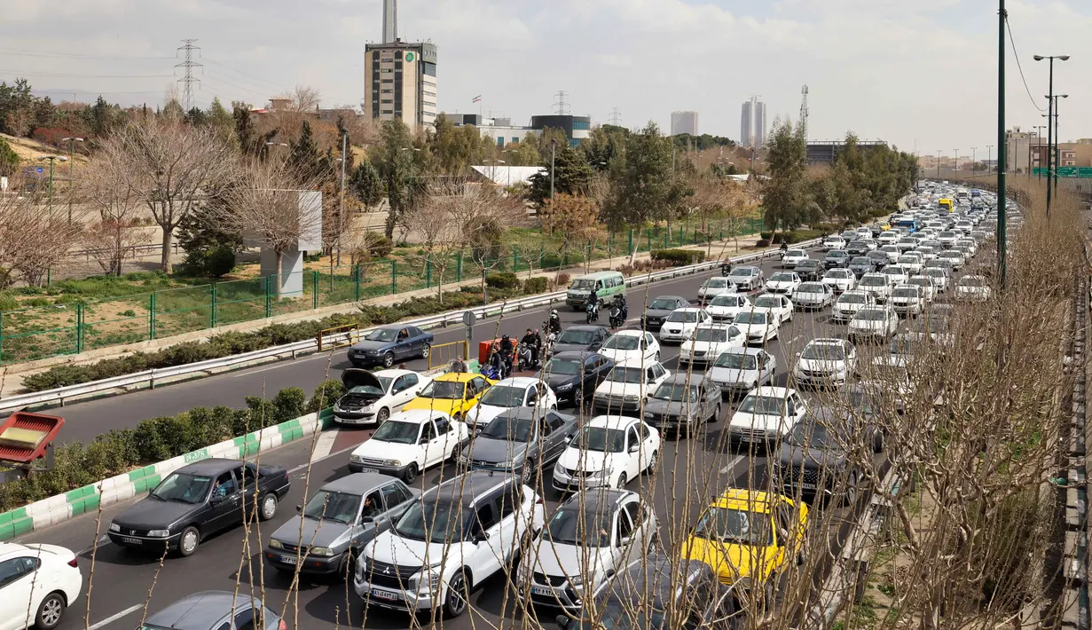 Banyak warga Iran mulai meninggalkan kota untuk mencari keselamatan. Tampak dalam foto, para pengendara mobil melintas di sebuah jalan di Teheran, Iran pada Sabtu 28 Februari 2026. (Atta KENARE/AFP)
