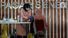 Tenaga kesehatan menyuntikkan vaksin COVID-19 kepada calon penumpang di Stasiun Pasar Senen, Jakarta, Minggu (4/7/2021). PT Kereta Api Indonesia Daop 1 Jakarta membuka layanan vaksinasi Covid-19 bagi penumpangnya di Stasiun Gambir dan Pasar Senen mulai Sabtu, 3 Juli 2021. (Liputan6.com/Johan Tallo)