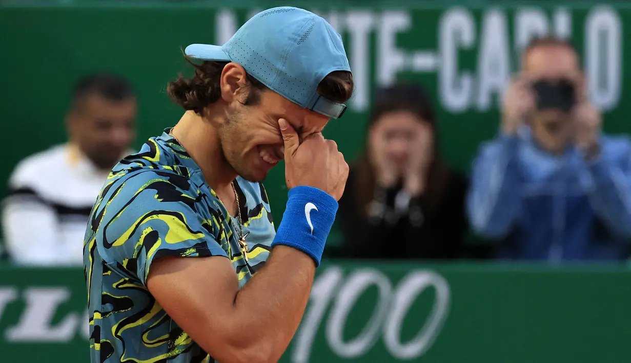 Ekspresi kegembiraan petenis Italia, Lorenzo Musetti setelah mengalahkan petenis Serbia, Novak Djokovic pada babak 16 besar Monte Carlo Open 2023 di Monte Carlo, Jumat (14/04/2023) dini hari WIB. Musetti menang dengan skor 4-6, 7-5, 6-4. (AFP/Valery Hache)