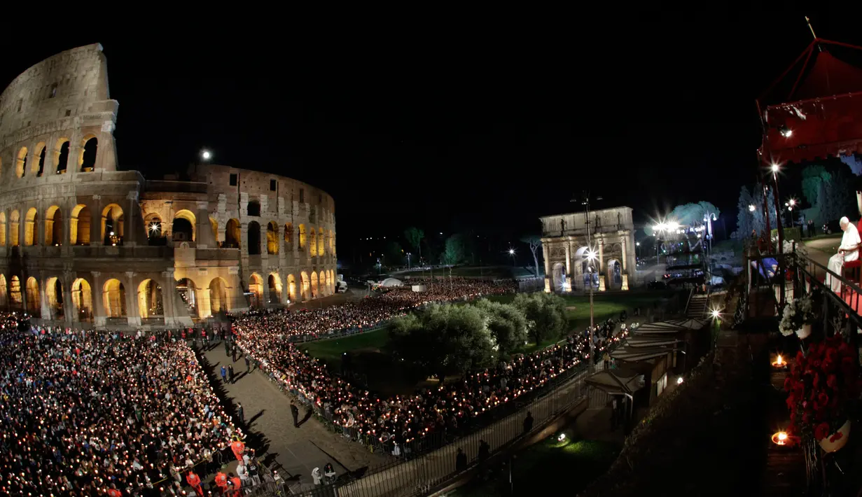 Paus Fransiskus (kanan) memimpin prosesi Jalan Salib saat memperingati Jumat Agung di sekitar bangunan  Colosseum, Roma, Italia, Jumat (19/4). Jalan Salib (Via Crucis) adalah devosi yang telah dipraktikkan oleh umat kristiani selama berabad-abad. (AP Photo/Andrew Medichini)