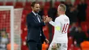 Striker Inggris, Wayne Rooney bersalaman dengan pelatih Gareth Southgate setelah pertandingan persahabatan melawan AS di Stadion Wembley, Inggris (16/11). Rooney telah mencetak 53 gol bersama timnas Inggris. (AFP Photo/Ian Kington)