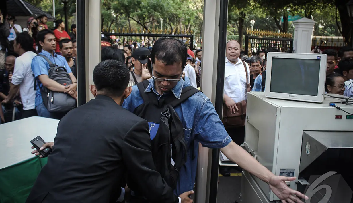 Petugas dengan seksama memeriksa setiap pengunjung yang datang ke Istana Negara, Jakarta, Senin (20/10/2014) (Liputan6.com/Faizal Fanani)