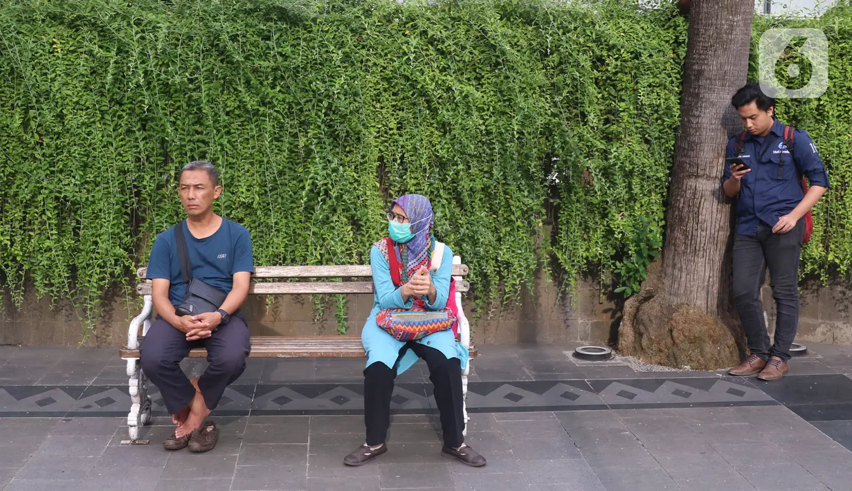 Sejumlah masyarakat melakukan jaga jarak aman di area publik di kawasan Thamrin, Jakarta, Rabu (18/3-2020). Jaga jarak atau prosedur social distancing measure harus diterapkan kepada masyarakat yang masih melakukan aktivitas di luar untuk memghindari penyebaran Covid-19. (Liputan6.com/Angga Yuniar)